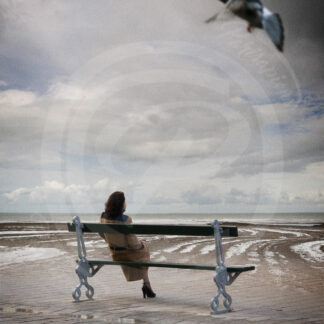 Photo-Montage Surréalisme Une femme assise sur un banc de Paris, devant l'immensité de l'océan